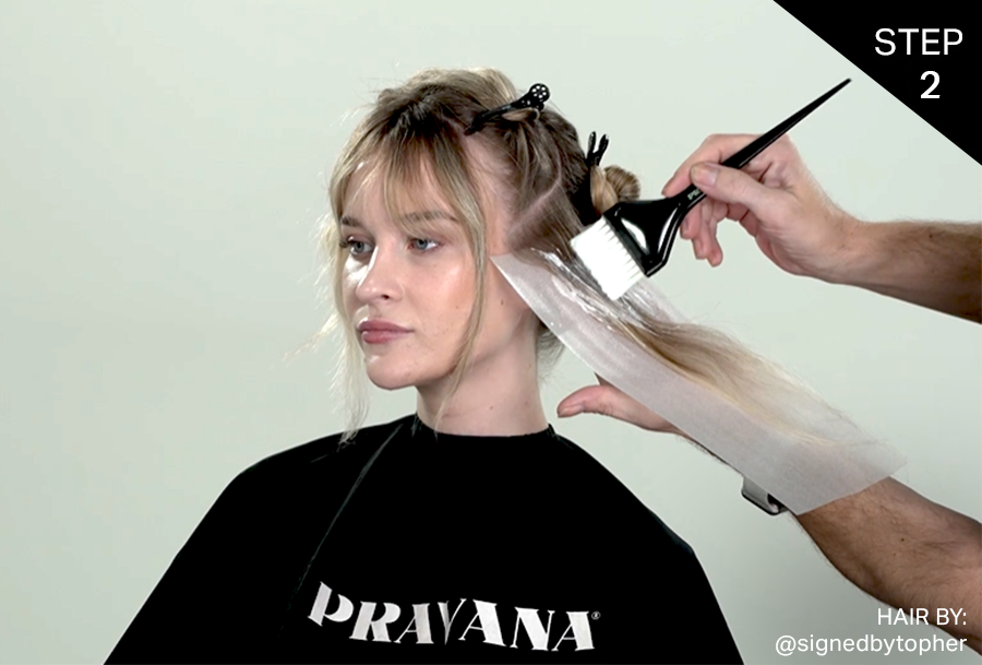 Applying free-hand balayage on the left side of the female hair model