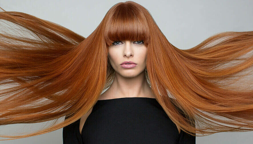 A Female Model with Long Orange Hair with Bangs