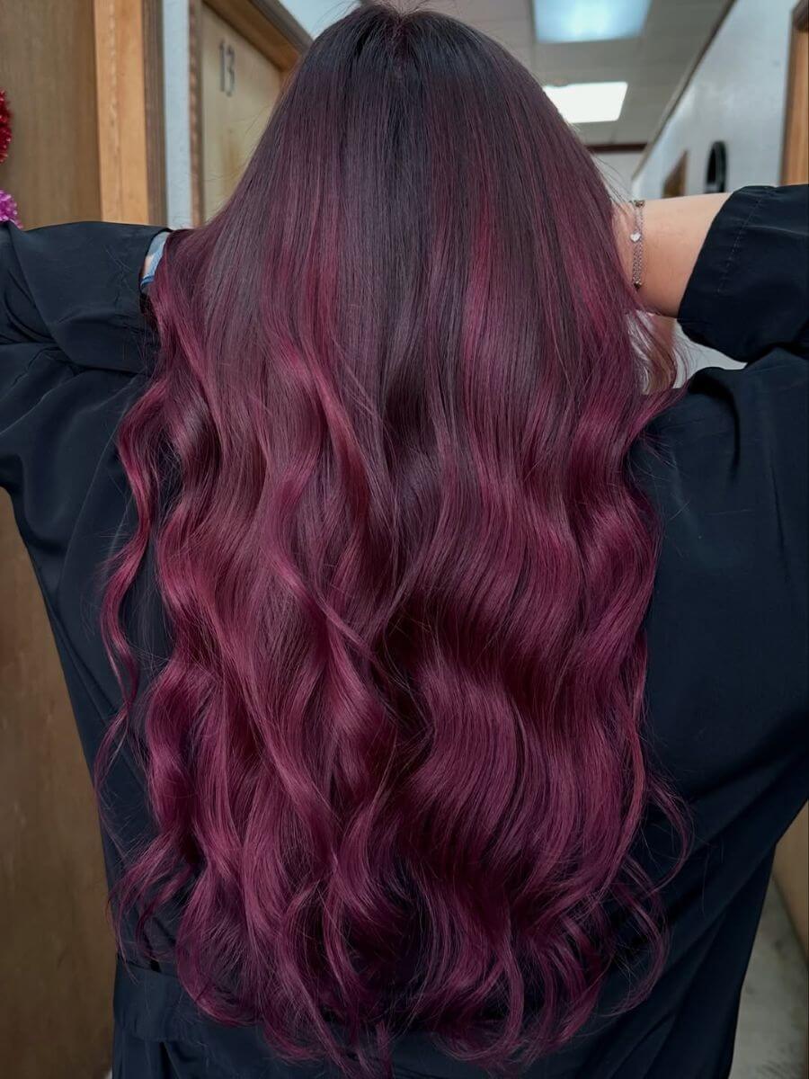 Model with intense red‑violet hair color with rich wine undertones and dramatic tonal depth image by @georgeeblancoo