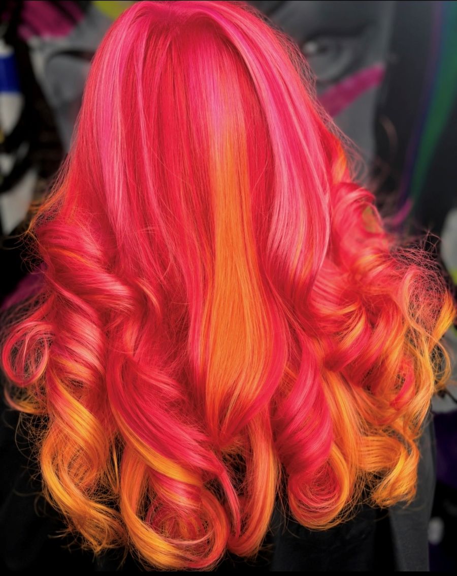 Like a fiery sunset, this vibrant hair color blend of neon orange, soft red and petal pink fashion tones mimics the colors in the favorite Polynesian Mai Tai cocktail.