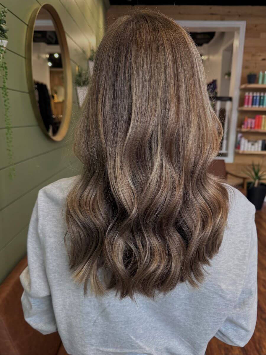 Burnt Butter Blonde hair color with a rich brunette base and lighter blonde ribbons create dimensional contrast.