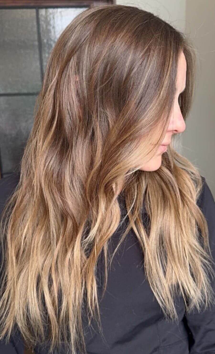 The Classic Brown Butter Blonde hair color featuring creamy blonde highlights concentrated around the face and tips of the hair.